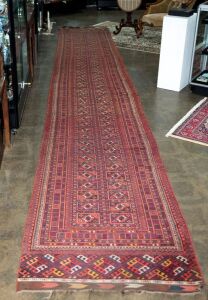 An impressive Turkoman runner with geometric pattern on red ground, 620 x 100cm