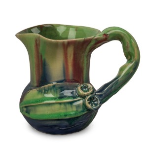 REMUED pottery jug with applied gumnuts, leaf and branch handle, glazed in early lime green, pink and blue, incised "Remued", 10.5cm high