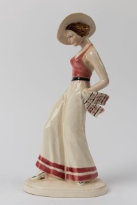 A Continental Art Deco porcelain statue of a lady in a hat, impressed stamp "H. M. T.", 31cm high