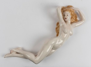 A Continental Art Deco porcelain statue of a reclining female nude with blonde hair, an imposing 61cm long