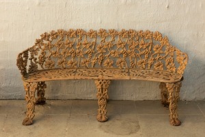 A vintage cast iron garden bench with grape motif, early to mid 20th century, 140cm across the arms