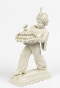 A Continental white porcelain statue of a Blackamoor carrying fruit, impressed pictorial fox mark to base, signed "H. Meisel", 30cm high