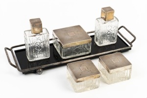 Set of five sterling silver topped vanity bottle and jars, early 20th century, together with a black glass and chrome tray, (6 items), the tray 32cm across the handles