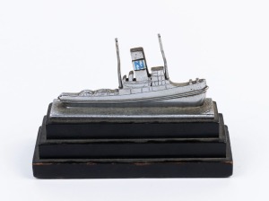 A silver plated tugboat paperweight ornament on ebonised pyramid plinth, circa 1920s, 11cm high, 15.5cm long