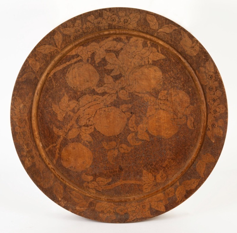 A folk art pokerwork circular plaque, circa 1910,  61cm diameter