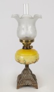 An antique kerosene lamp, cast metal base with yellow glass font, double burner and reproduction shade and chimney, 19th century,  ​​​​​​​57cm high overall