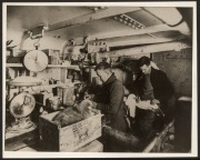 THE B.A.N.Z. ANTARCTIC EXPEDITION: Official original photograph by Captain Frank Hurley: Image A24 - Title: Crew members preparing bird specimens for museum distribution on board the Discovery, with official "MAWSON ANTARCTIC EXPEDITION" handstamp and rel