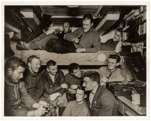 THE B.A.N.Z. ANTARCTIC EXPEDITION: Official original photograph by Captain Frank Hurley: Image A27 - Title: Explorers entertained in Antarctica, with official "MAWSON ANTARCTIC EXPEDITION" handstamp and release date "TUESDAY APR.15, 1930" verso, together 