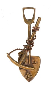 A yellow gold Western Australian goldfields miner's brooch, crossed pick and shovel form with entwined rope, bucket and nugget specimen, 19th/20th century, stamped "W.A.", ​​​​​​​5.2cm wide, 5.5 grams