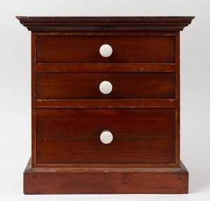 An antique Australian cedar three drawer miniature chest with porcelain knobs, late 19th century, ​​​​​​​36cm high, 36cm wide, 28cm deep