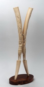 An African carved ivory figural sculpture on burl timber base, early to mid 20th century, 61cm high