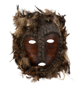 A tribal mask, tortoise shell, feather, earth and shell, unknown origin, 20th century, 28cm high overall