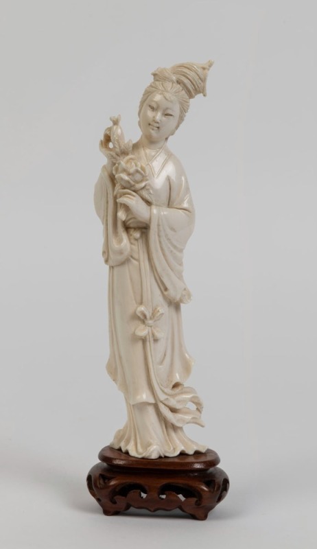 A Chinese carved ivory statue of a lady, on carved wooden base, 19th/20th century, ​​​​​​​21cm high overall