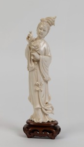 A Chinese carved ivory statue of a lady, on carved wooden base, 19th/20th century, 21cm high overall
