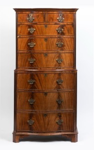 An antique English flame mahogany chest on chest in the Georgian manner, with serpentine front and fluted canted corners, late 19th century, 180cm high, 87cm wide, 54cm deep