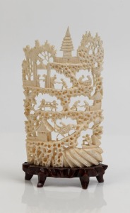 A Chinese carved ivory landscape ornament on carved wooden stand, early to mid 20th century, 16cm high overall