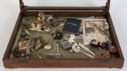 A glass-top display case with various items including an Australian 1938 Crown, several clockwork toys, spoons, badges, etc. 37 x 51 x 7.5cm. - 2