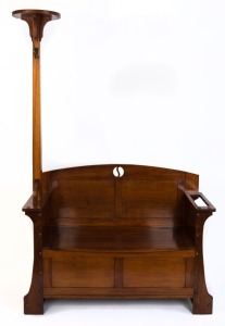 An Australian blackwood Arts & Crafts hallseat with attached hat tree, pierced roundels and a lift-top trunk, circa 1920, 194cm high, 122cm wide, 45.5cm deep