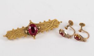 An antique yellow gold bar brooch and pair of earrings, both set with red stones, 19th century, the brooch 5cm wide, 7 grams total