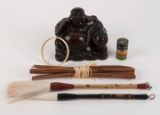 A Chinese carved wooden Buddha statue, two calligraphy brushes, an ivory armband, Chinese cloisonne pillbox stack and a bundle of cinnamon sticks, 19th/20th century, (6 items), the Buddha statue 14cm high