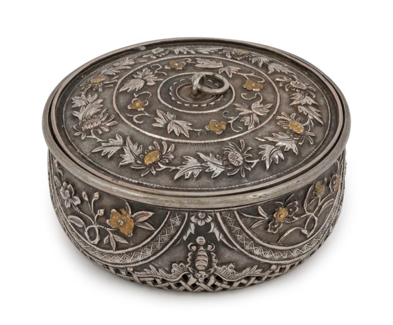 An antique Vietnamese silver circular box with pierced work base and gilt highlights, 19th century. The side walls decorated with highly chased works divided into four semi-circular panels with flowers of the four seasons, separated by four bats (symbol o