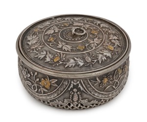 An antique Vietnamese silver circular box with pierced work base and gilt highlights, 19th century. The side walls decorated with highly chased works divided into four semi-circular panels with flowers of the four seasons, separated by four bats (symbol of happiness). The lift off lid is divided into concentric rings filled with floral scrolls, with gilding to the flowers. 3.5cm high, 8cm diameter
