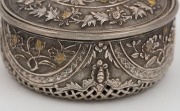 An antique Vietnamese silver circular box with pierced work base and gilt highlights, 19th century. The side walls decorated with highly chased works divided into four semi-circular panels with flowers of the four seasons, separated by four bats (symbol o - 2