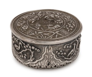 An antique Vietnamese floral circular box with fine repousse work depicting animals and flowers with pierced basket weave base, 19th century,  4cm high, 7.5cm diameter