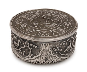 An antique Vietnamese floral circular box with fine repousse work depicting animals and flowers with pierced basket weave base, 19th century, 4cm high, 7.5cm diameter