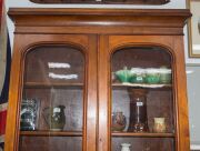 An Australian cedar bookcase with a cavetto pediment, two arch-top glazed doors, conforming lower panelled doors, an ogee-moulded drawer and carved corbels, 19th century, 235cm high, 114cm wide, 44cm deep - 4