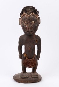 An ancestral figure, carved wood, hair, shell and fibre with remains of ochre finish, Papua New Guinea, 46cm high