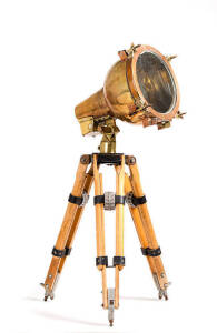 Ships brass spot light. Converted to electricity, on wooden tripod stand, mid 20th century. Lamp length 33cm, diameter 24cm