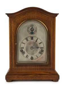 An antique German spring driven table clock in oak case, 8 day three train movement with quarter chiming on a nest of four coiled gongs, circa 1900, 23cm high
