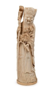 An antique Chinese carved ivory statue of a man with dragon staff and peonies, Qing Dynasty, 19th/20th century, 23.5cm high