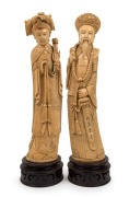A pair of Chinese&nbsp;carved ivory statues of a Mandarin court official and wife, on carved wooden stands,&nbsp;19th/20th century, ​​​​​​​34.5cm high