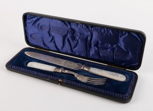 An antique English sterling silver knife and fork with engraved decoration and mother of pearl handles, stamped "T.L.", made in Sheffield, circa 1901, in plush fitted box, the box 30cm wide