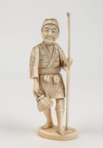 An antique Japanese carved ivory statue of a fisherman with paddle, Meiji period, 19th/20th century, red seal mark to base, 14.5cm high