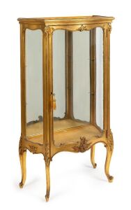 An antique French gilded display vitrine with serpentine glazed door, green onyx top, glass shelves and carved cabriole legs, 19th/20th century, 140cm high, 78cm wide, 40cm deep