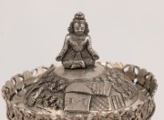 An antique Indian silver tea caddy with ornate village scene decoration, lion's paw feet and seated figural finial, 19th/20th century, ​​​​​​​14.5cm high, 276 grams - 2