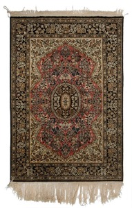 A Persian hand-knotted silk rug with ornate floral motif with black, olive and terracotta ground,  ​​​​​​​172cm x 112cm 