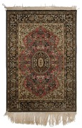 A Persian hand-knotted silk rug with ornate floral motif with black, olive and terracotta ground,&nbsp; ​​​​​​​172cm x 112cm&nbsp;