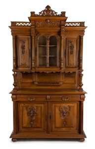 A French walnut court cupboard with glazed central doors to the upper section flanked by fully fluted columns. The base with two drawers above a pair of well carved doors, circa 1890 257cm high, 151cm wide, 54cm deep