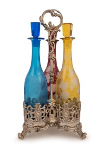 An antique silver plated decanter stand with three finely engraved coloured glass decanters, mid 19th century, 44cm high overall