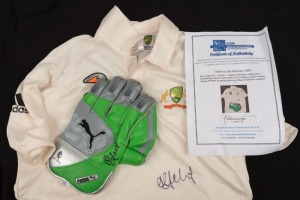 ADAM GILCHRIST signed Puma Wicket-keeping glove and a replica Australian Test team shirt (short sleeves). (2 items). With ASM Certificate of Authenticity.
