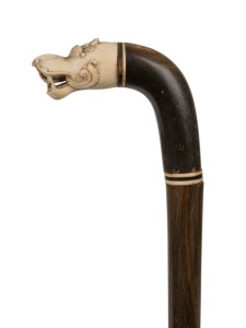 An antique walking stick with carved ivory mythical animal head handle, horn shaft with bone spacers and ivory ferrule, 19th century, 96cm high