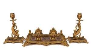 A superb three piece antique French desk set comprising of a double inkwell and pair of candle sticks, sumptuously crafted in gilt bronze and copper, 19th century, the inkwell 37cm wide, the candle sticks 25cm high