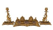 A superb three piece antique French desk set comprising of a double inkwell and pair of candle sticks, sumptuously crafted in gilt bronze and copper, 19th century, the inkwell 37cm wide, the candle sticks 25cm high