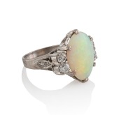 A platinum ring, set with a solid Coober Pedy white opal, flanked by two pairs of brilliant cut white diamonds, 6.9 grams total - 2