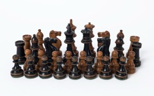 An antique set of chess pieces in the Staunton style, turned and ebonized boxwood, housed in a period timber case, 19th century, the kings 8.5cm high