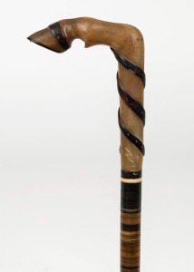 An antique walking stick, carved horn handle with segmented horn shaft and metal ferrule, 19th century, 84cm high